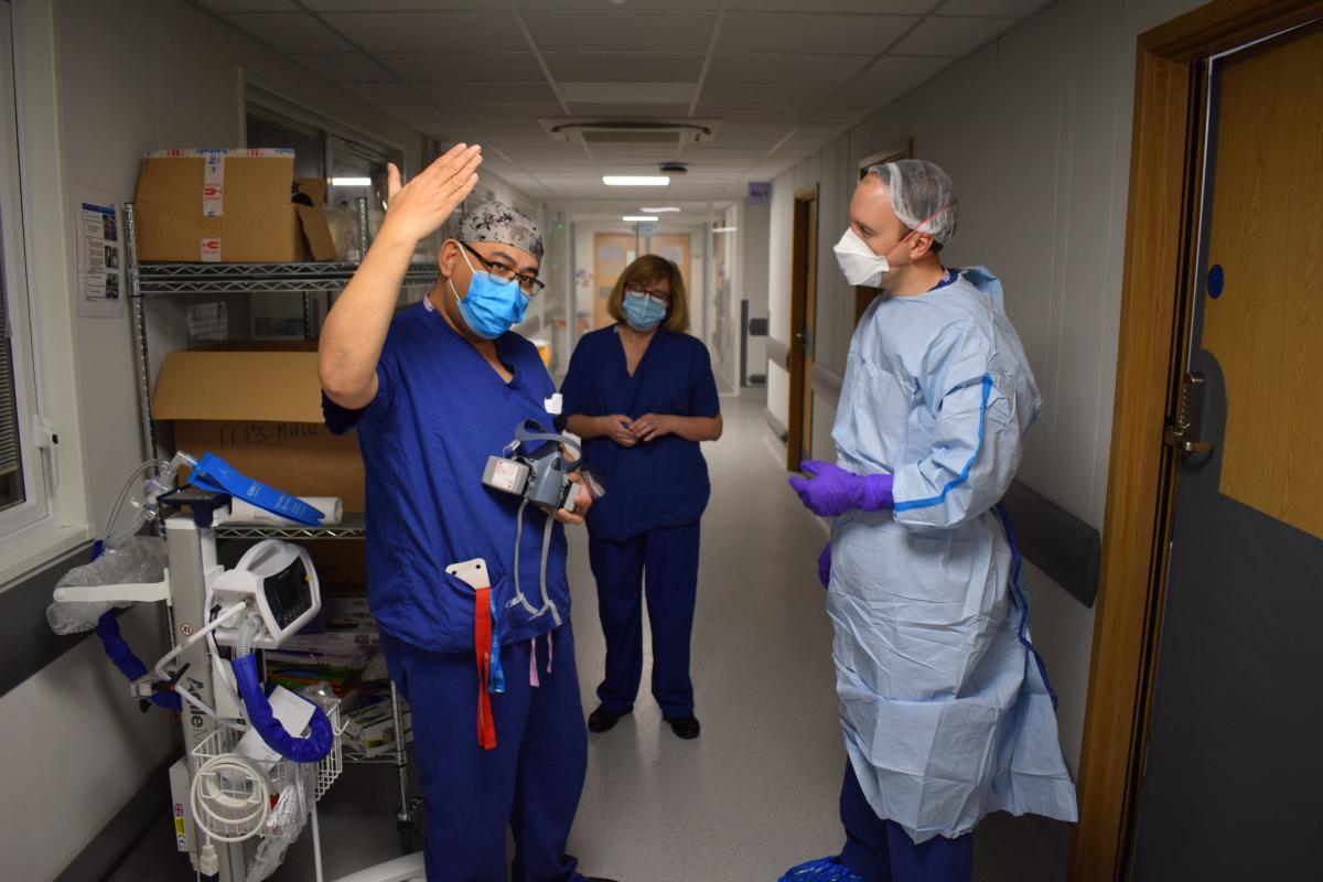 Matt Hancock talks to a member of staff at Basildon Hospital wearing PPE